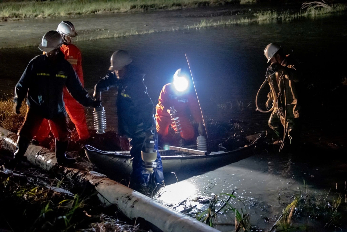 Nỗ lực đưa sứ điện ra cánh đồng còn ngập lụt ở xã Hoà Thịnh để thay thế, đồng thời dựng lại trụ điện bị đổ do lũ.