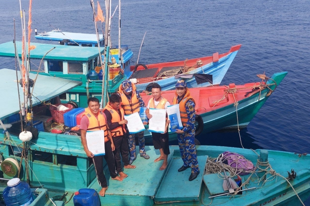Phát tờ rơi, tuyên truyền pháp luật cho ngư dân vươn khơi an toàn