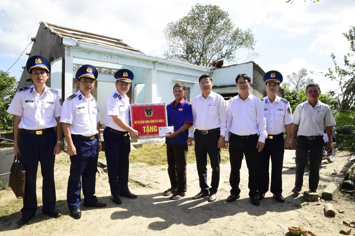 Đại tá Lê Huy, Chính ủy Vùng Cảnh sát biển và lãnh đạo xã Bình Hiệp trao quà hỗ trợ cho gia đình  ông Mạc Tâm Dung, thôn An Hội, xã Bình Hiệp, bị tốc mái hoàn toàn trong bão số 13