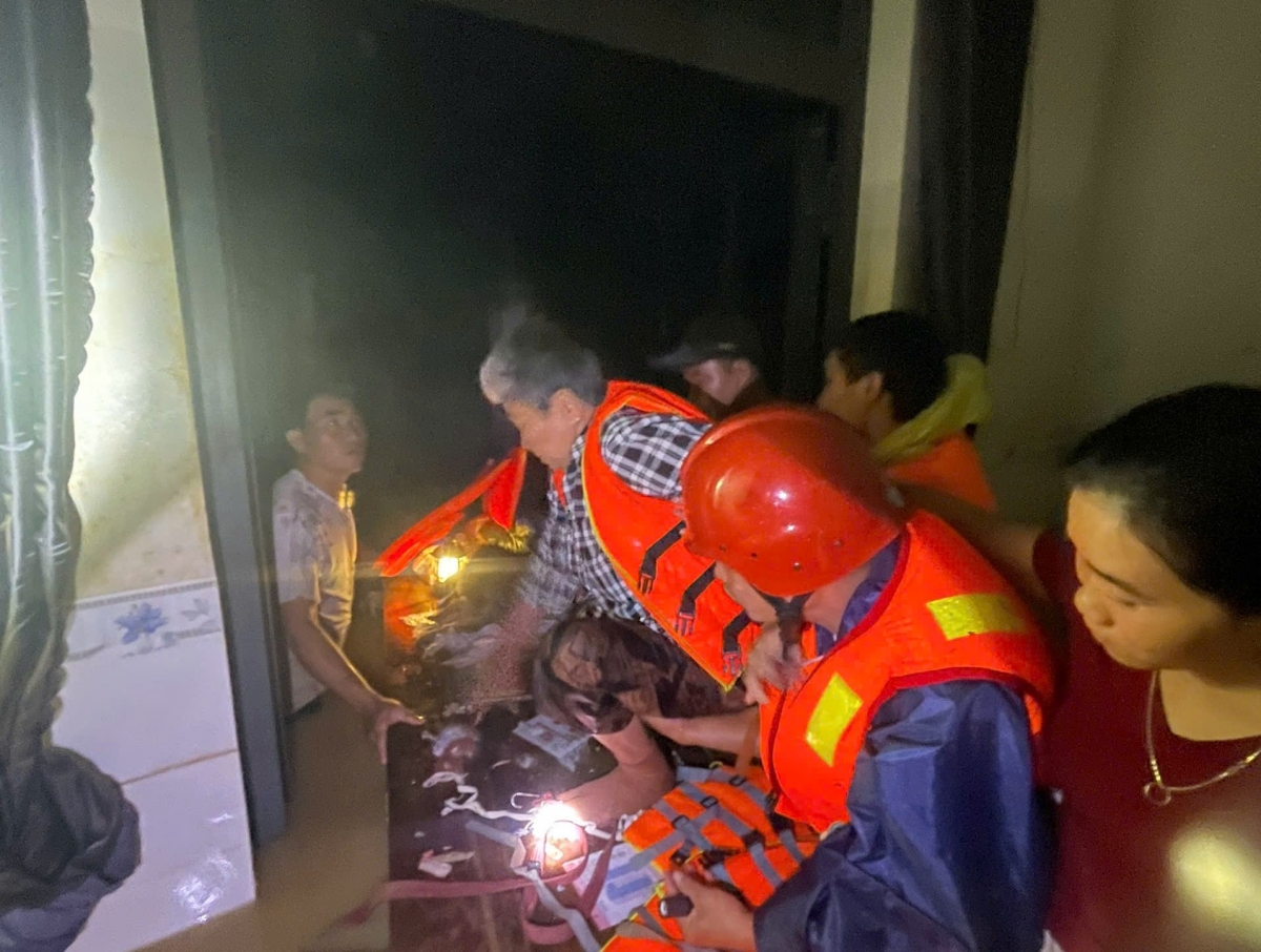 Một người cao tuổi được lực lượng chức năng đưa đến nơi an toàn trong đêm 20/11