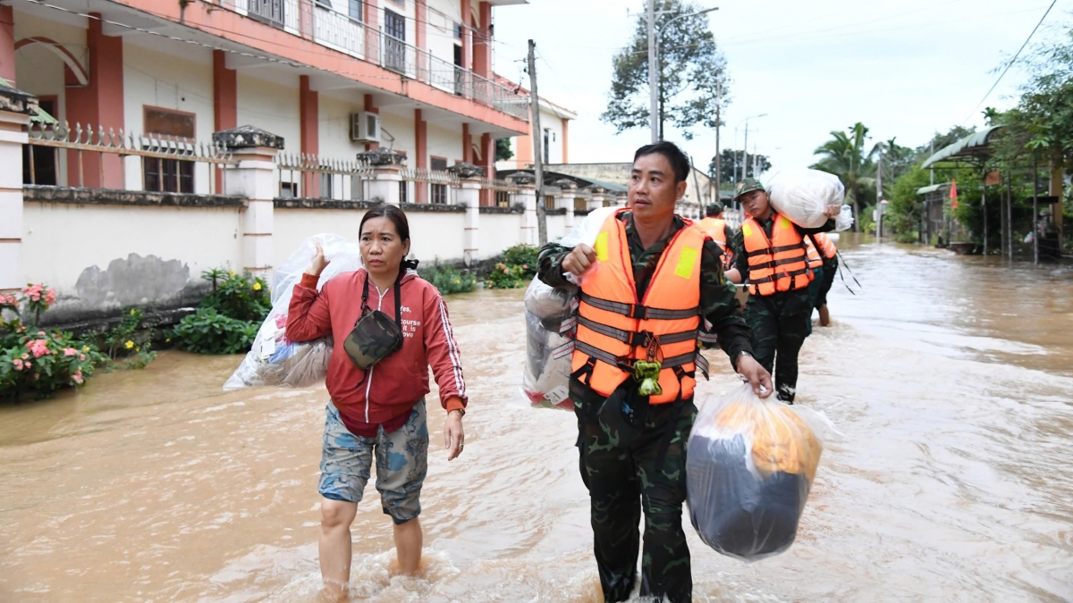 Cán bộ, chiến sĩ hỗ trợ người dân di dời đến nơi ở an toàn.