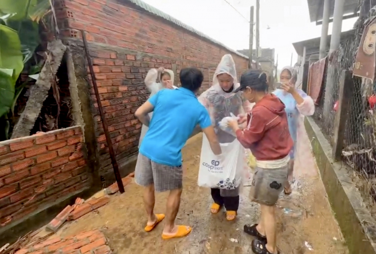 Các cán bộ, tình nguyện viên tỏa ra đưa cơm đến các địa bàn dân cư tại vùng lũ.