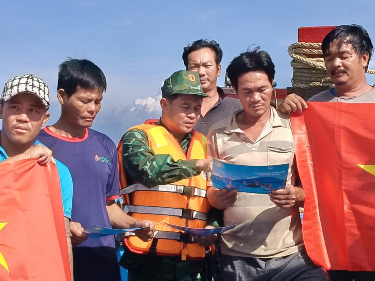 Cán bộ Hải đoàn 48 phát tờ rơi cho bà con ngư dân