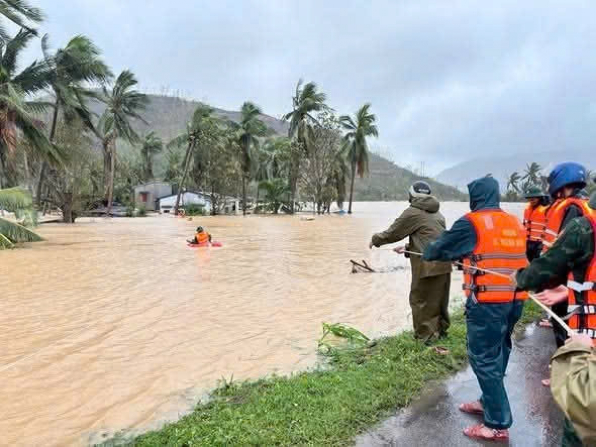 Công an xã Xuân Cảnh dùng dây vào nơi ngập sâu để đưa giải cứu người dân