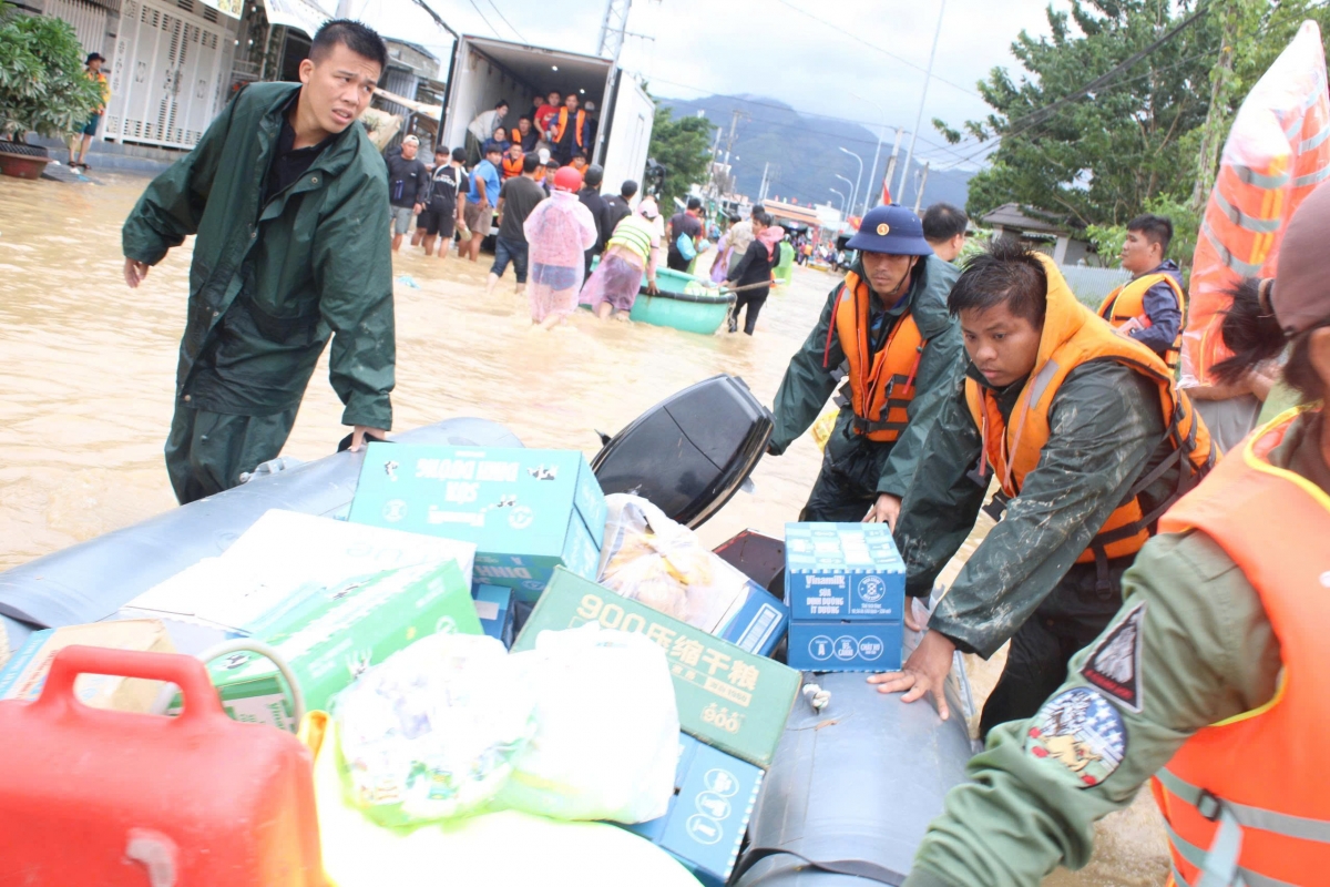 Cán bộ, chiến sĩ Tiểu đoàn 795 tiếp tế lương thực và nước uống cho bà con vùng lũ