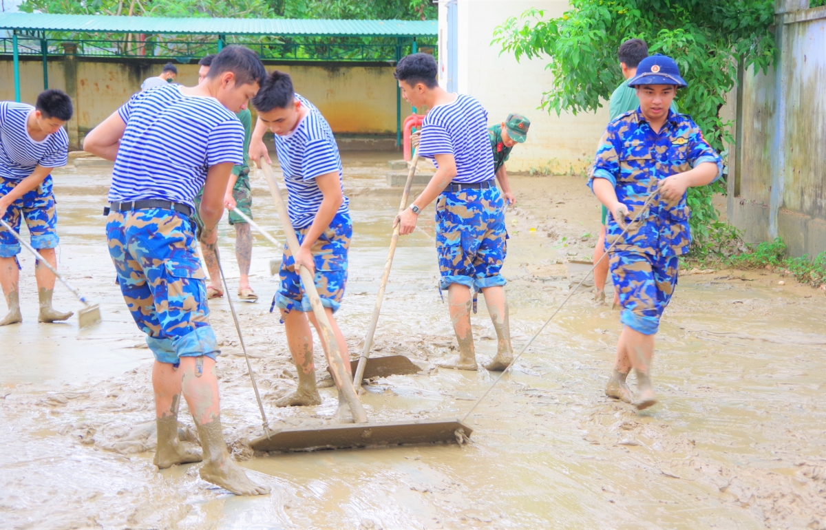 Học viên dọn và đưa một lượng lớn bùn dất, làm sạch tại một điểm trường.