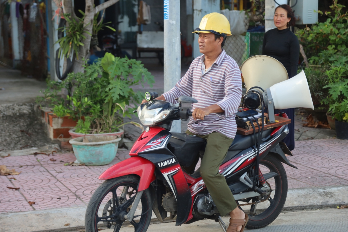 Ông Phạm Hồng Hưng, Tổ trưởng Tổ dân phố Thạch Bi 2, phường Sa Huỳnh dùng loa để tuyền truyền về cách ứng phó bão số 13.