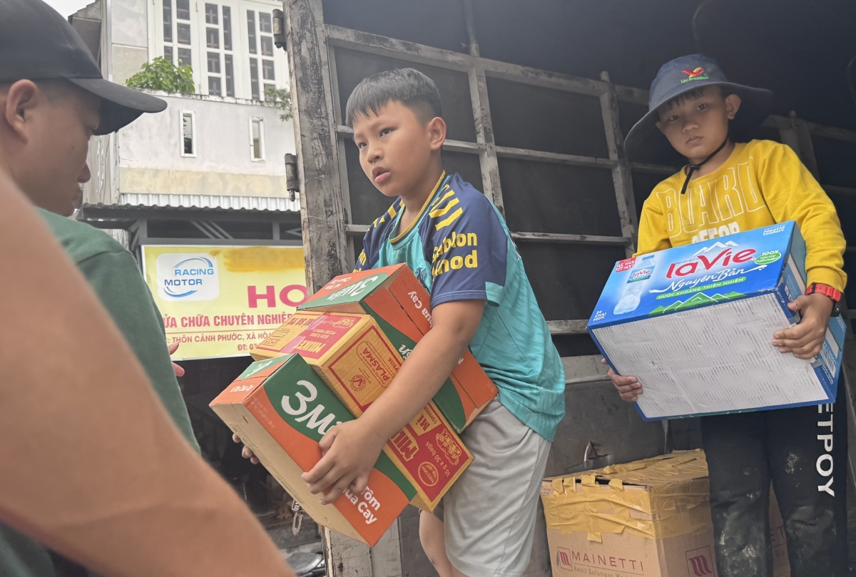 Một số học sinh ở xã Đông Hoà, tỉnh Đắk Lắk tham gia vận chuyện mỳ tôm cấp phát cho bà con.