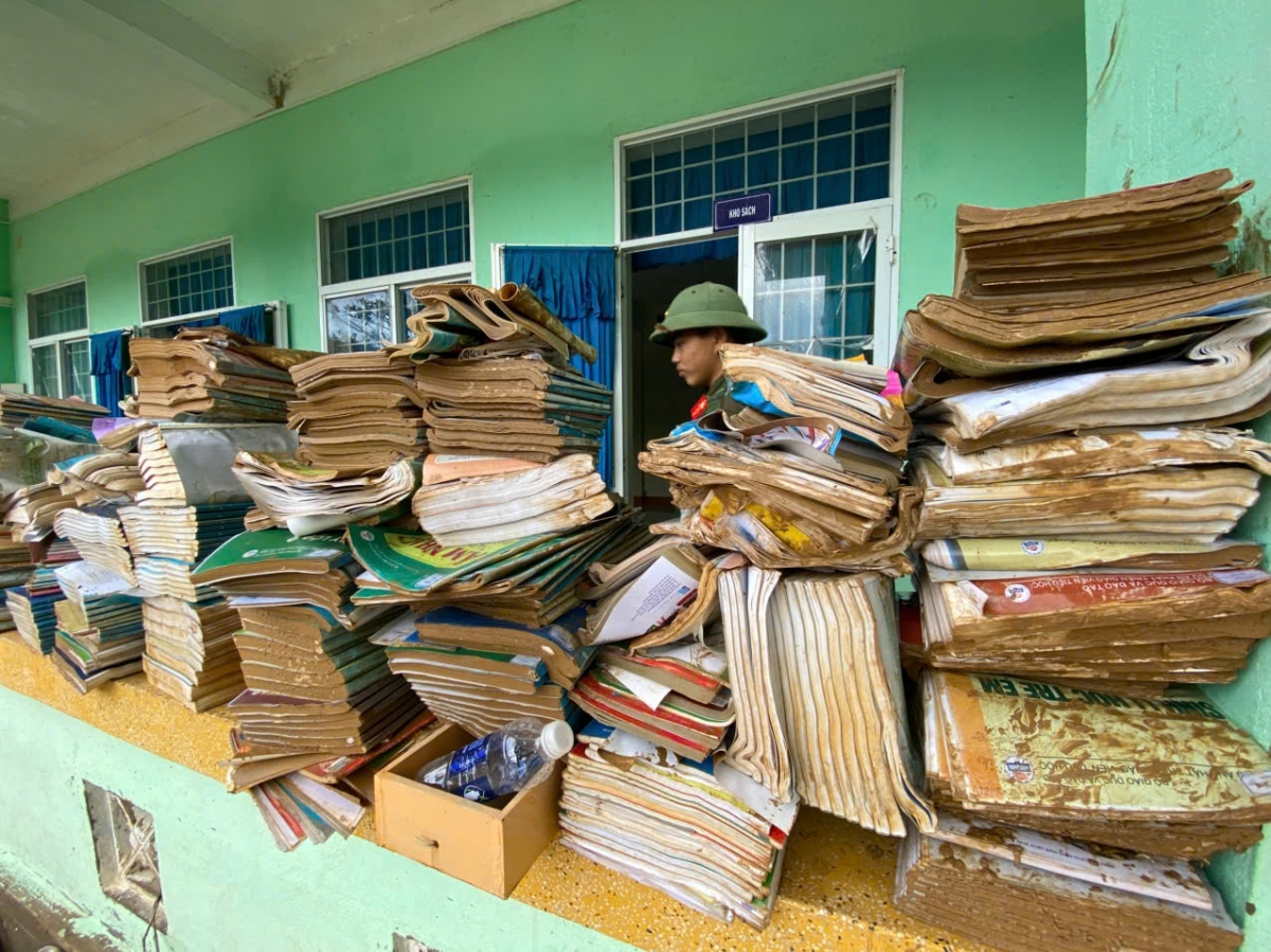 Sách vở học sinh thấm bùn đất vì nước lũ.