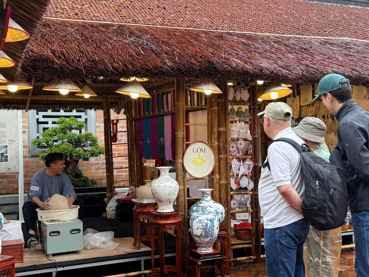 Du khách quốc tế thích thú khi xem nghệ nhân thực hành làm gốm tại sự kiện