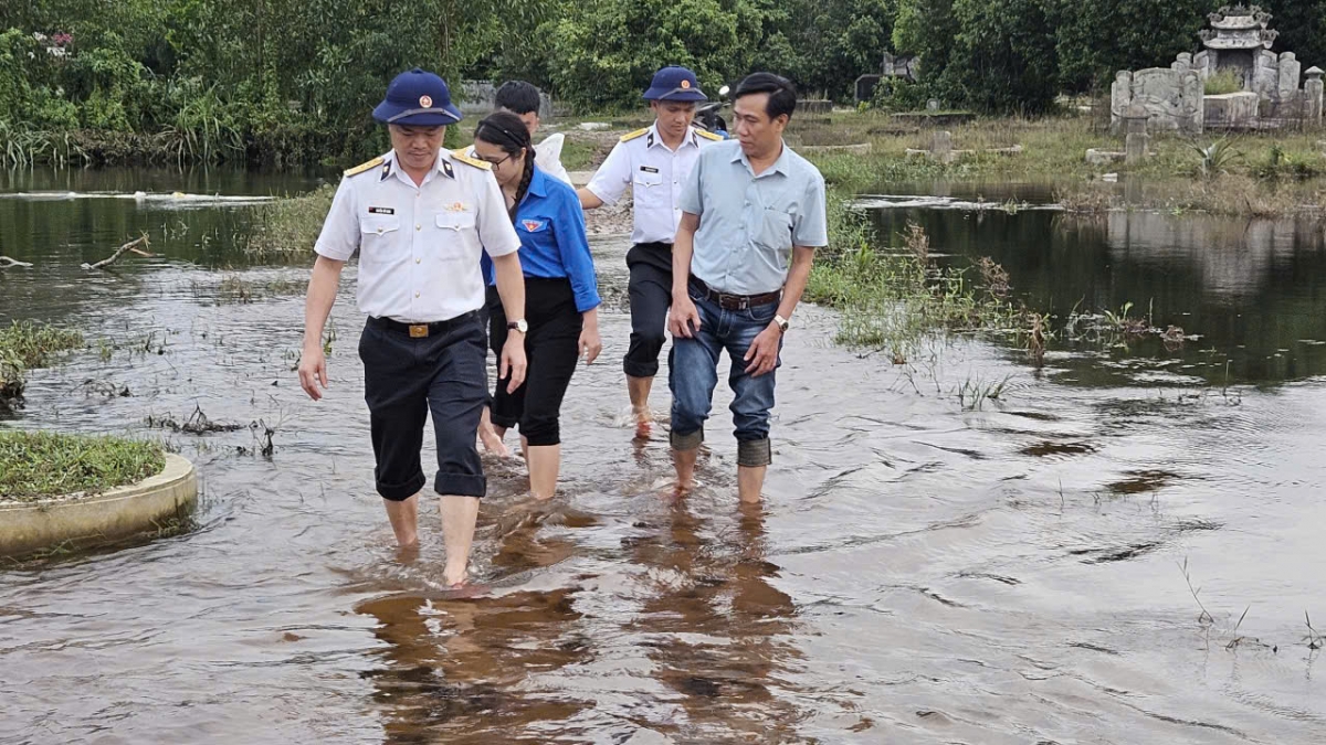 Đoàn công tác lội nước vào trao quà cho người dân