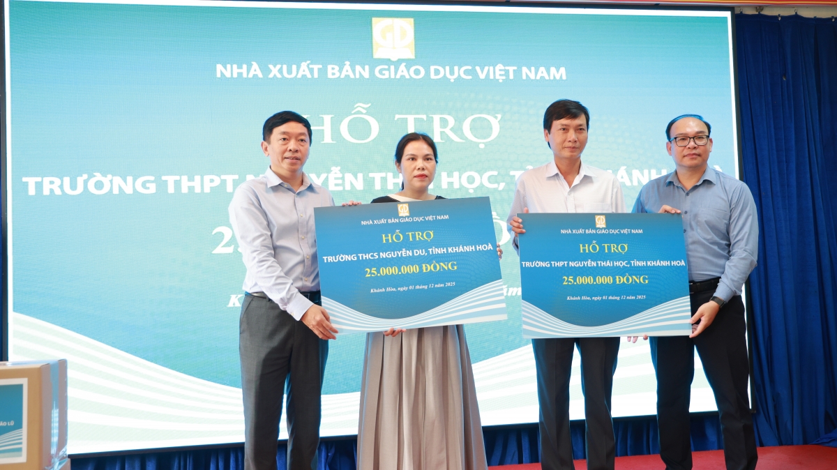 Đại diện Nhà xuất bản Giáo dục Việt Nam trao bảng tượng trưng hỗ trợ kinh phí cho 2 trường học bị ảnh hưởng mưa lũ.