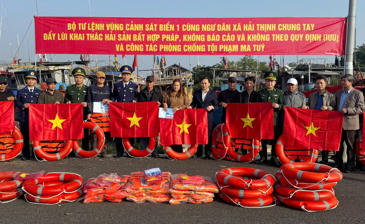 Lực lượng chức năng tặng cờ Tổ quốc, áo phao cho ngư dân tại cảng cá Ninh Cơ, xã Hải Thịnh