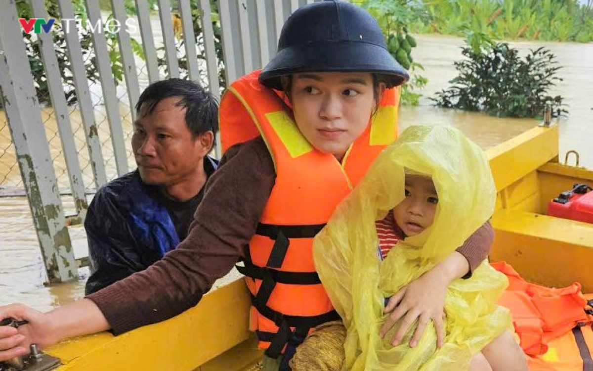 Cháu bé thoát khỏi lũ dữ được đưa lên xuồng ra khỏi khu vực mất an toàn.