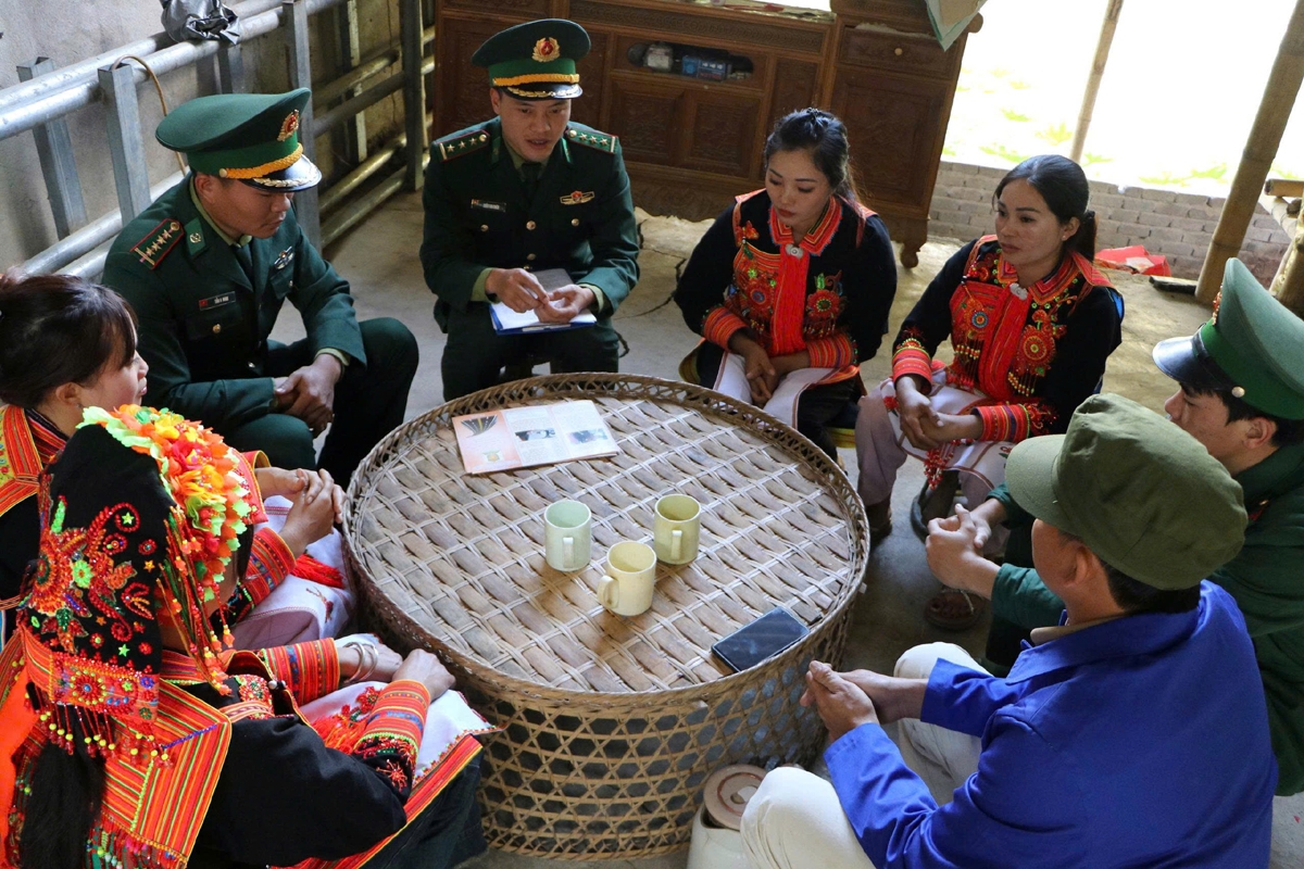 Cán bộ Đồn Biên phòng cửa khẩu Ma Lù Thàng tuyên truyền người dân bản Hùng Pèng vững tin bám bản, bám đất xây dựng quê hương