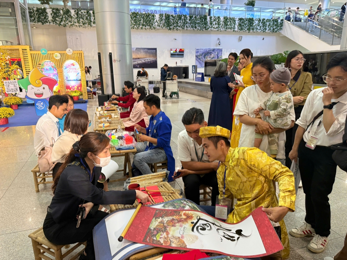 Du khách xem viết thư pháp ngay tại Cảng Hàng không quốc tế Tân Sơn Nhất (Ảnh: T.H)