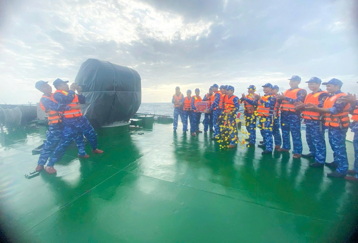 Đại úy Đỗ Đức Tĩnh ( thứ 2 từ bên trái sang) đang tác nghiệp trên biển