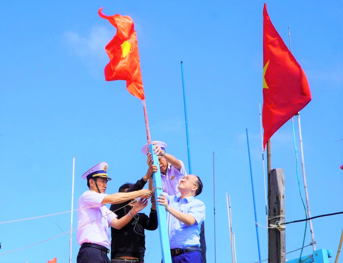 Chuẩn Đô đốc Nguyễn Hữu Thoan trực tiếp tặng cờ Tổ quốc và cùng ngư dân treo cờ Tổ quốc trên Tàu cá của ngư dân tại Cảng cá Phú Lạc, phường Hòa Hiệp, tỉnh Đắk Lắk