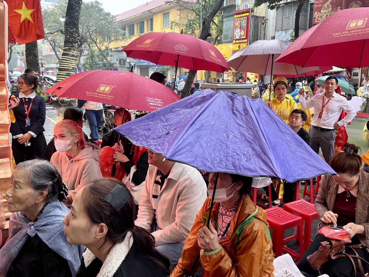 Từ sáng sớm, dù trời mưa, người dân xếp hàng trước các cửa hàng vàng, chờ đến lượt mua vàng trong Ngày vía Thần Tài.