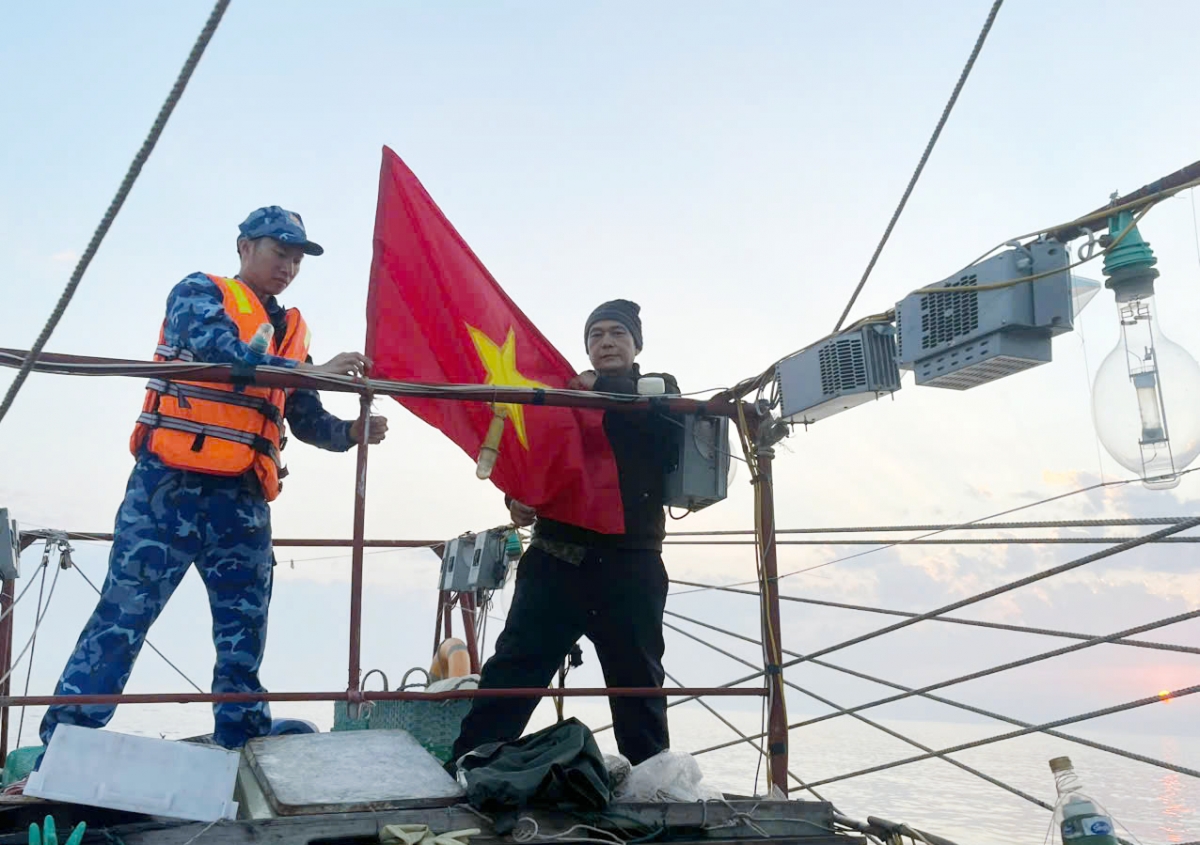 Tổ công tác tàu CSB 4036 treo cờ Tổ quốc trên tàu cá của ngư dân