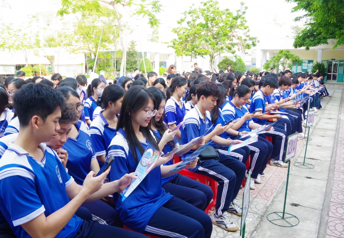 Các học sinh được hướng dẫn sử dụng điện thoại thông minh khai thác thông qua quét mã QR và truy cập các nền tàng số để tìm hiểu chi tiết về công tác tuyển sinh quân sự năm 2026