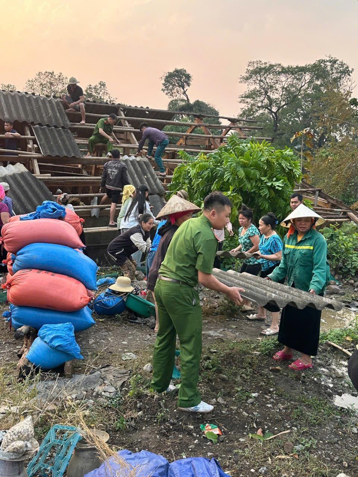 Trong sáng nay, các lực lượng chức năng cùng người dân các bản tháo dỡ nhà để sửa và lợp lại mái nhà.