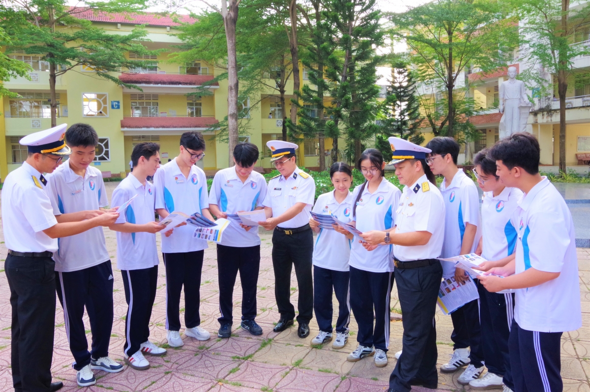 Cán bộ Học viện Hải quân trao đổi, chia sẻ, cung cấp thông tin trong tờ rơi về công tác tuyển sinh vào Học viện Hải quân năm 2026