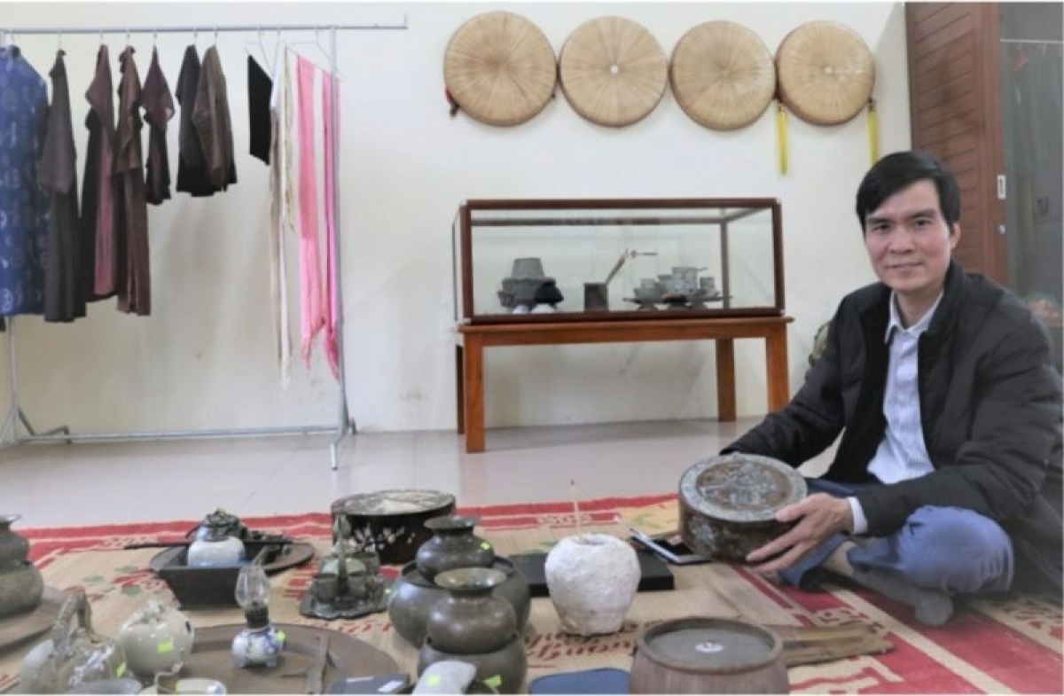 Liền anh Dương Đức Thắng bên những hiện vật xưa cũ nhuộm màu thời gian.