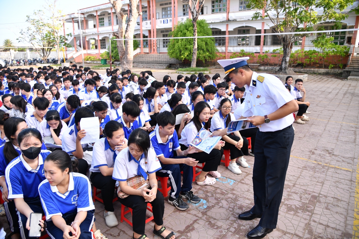 Đại diện đoàn công tác phát tờ rơi hướng dẫn tuyển sinh cho học sinh