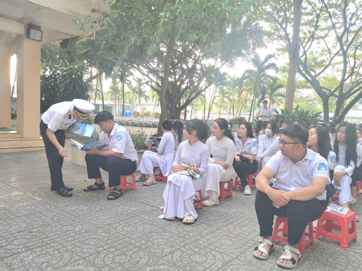Tuyên truyền viên của Lữ đoàn phát tờ rơi tuyên truyền về Học viện Hải quân cho các bạn học sinh.
