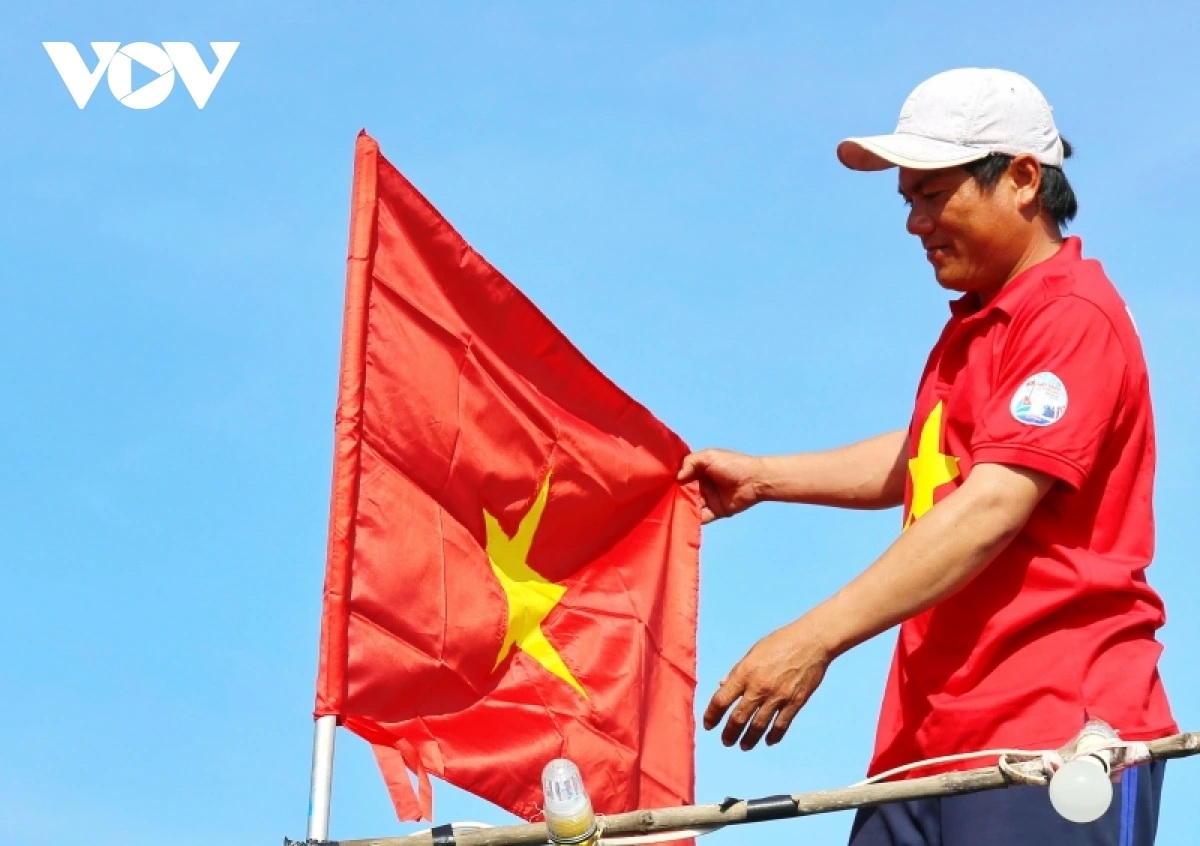 Ngư dân thay mới cờ Tổ quốc trên tàu cá chuẩn bị ra khơi