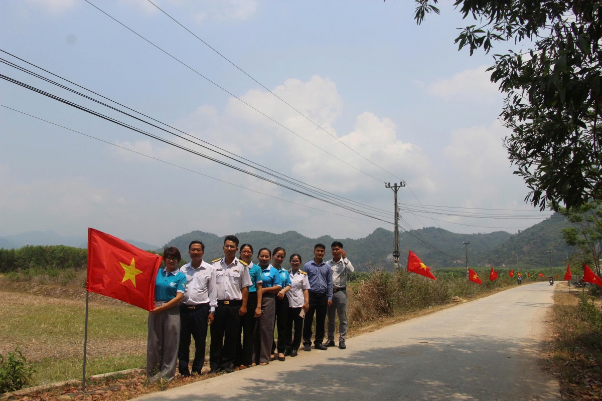 Đoàn công tác Hội Liên hiệp Phụ nữ đặc khu Trường Sa chụp ảnh với lãnh đạo xã Bắc Khánh Vĩnh tại tuyến đường cờ