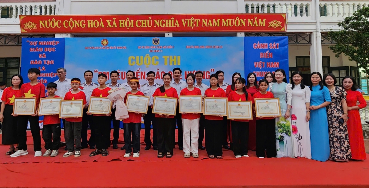 Thượng tá Lê Anh Sơn, BTĐU, Chính ủy Hải đoàn 11 trao thưởng và chụp ảnh lưu niệm cùng các em học sinh đạt giải.