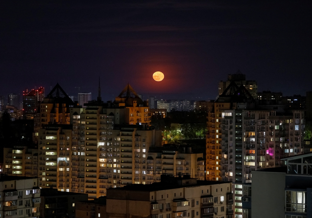 Trăng tròn mọc lên trên bầu trời thành phố Kyiv, Ukraine (ảnh: Reuters)