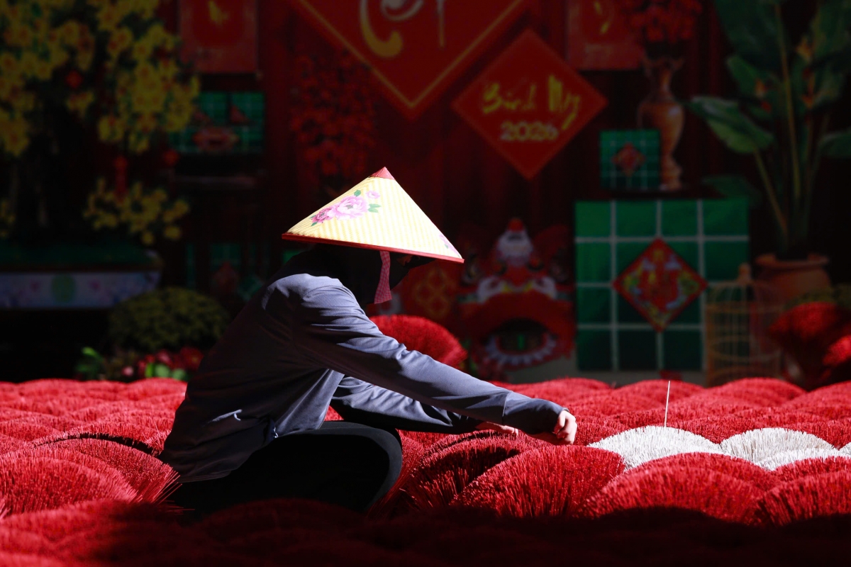Người dân làng nghề đang sắp xếp những bó chân hương phơi nắng.