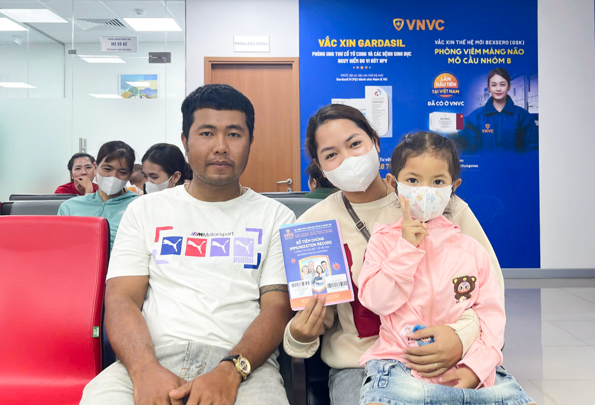 Vợ chồng chị H’Hiền Mlô đưa con gái 4 tuổi tiêm vắc xin não mô cầu tại VNVC Cư M'gar.