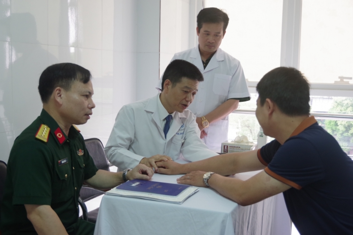 PGS.TS Lê Hữu Doanh, Giám đốc BV Da liễu Trung ương (người ngồi giữa) thăm khám cho bệnh nhân tại Phòng khám chuyên đề Vảy nến BV Quân y 7
