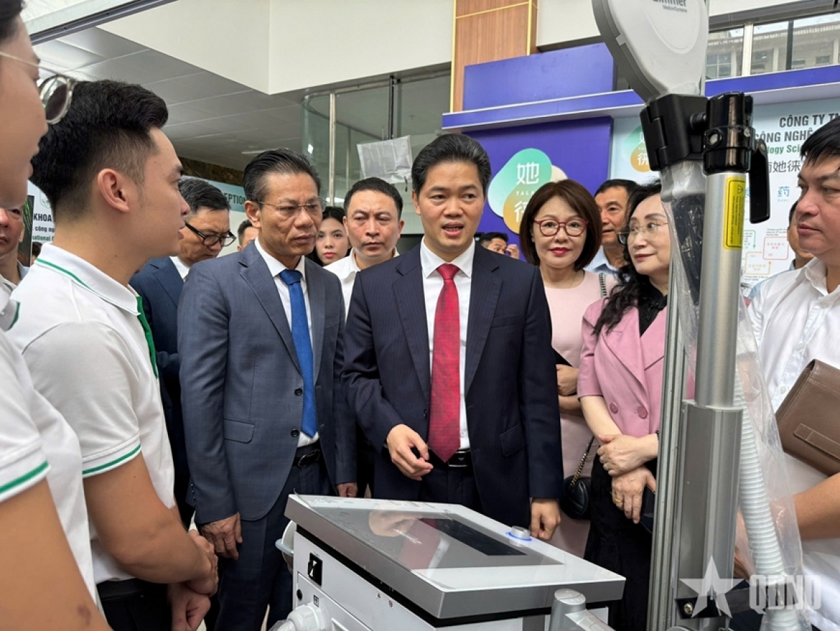 Thứ trưởng Thường trực Bộ Y tế Vũ Mạnh Hà và các đại biểu tham quan triển lãm y học cổ truyền ứng dụng công nghệ tại hội thảo.