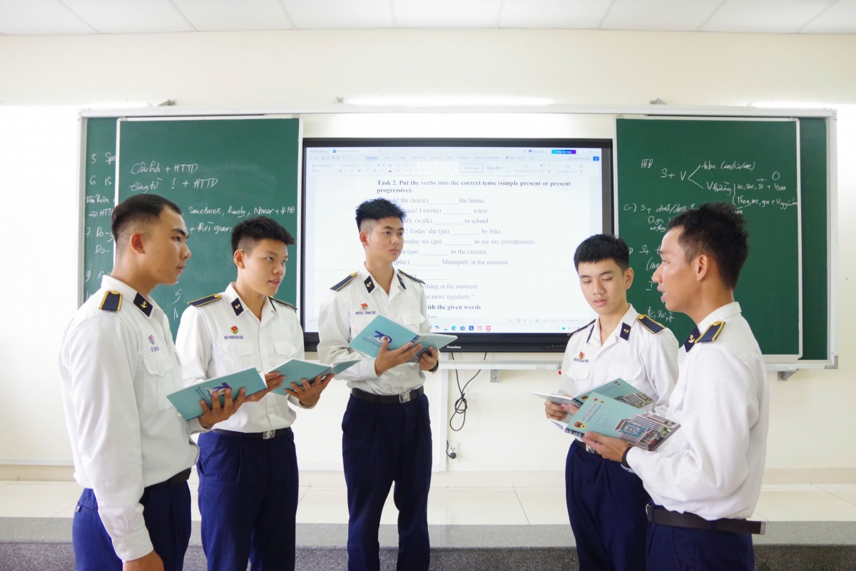 Binh nhất Nguyễn Lê Thành Triết (đứng giữa) trao đổi học tập tiếng Anh trong giờ tự học tại giảng đường 