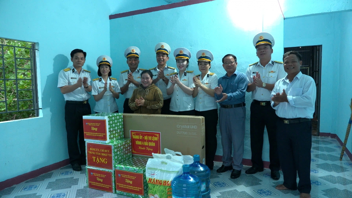 Các đại biểu, cán bộ, chiến sĩ Vùng 4 Hải quân chụp ảnh lưu niệm cùng gia đình được bàn giao nhà