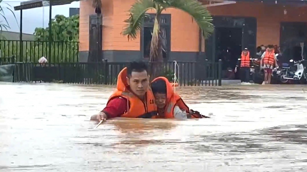 Lực lượng cứu hộ dìu cõng người già, trẻ em tới nơi an toàn.