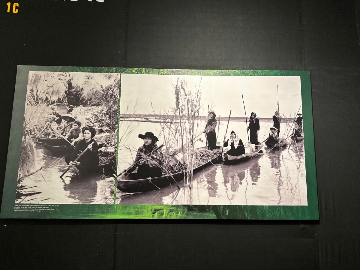 Hình ảnh các nữ chiến sỹ chèo xuồng ba lá vận chuyển vũ khí, vật dụng vào chiến trường.
