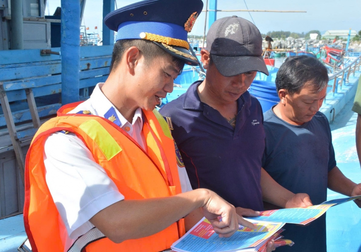 Lực lượng Cảnh sát biển hướng dẫn ngư dân các nội dung tuyên truyền trên tờ rơi.