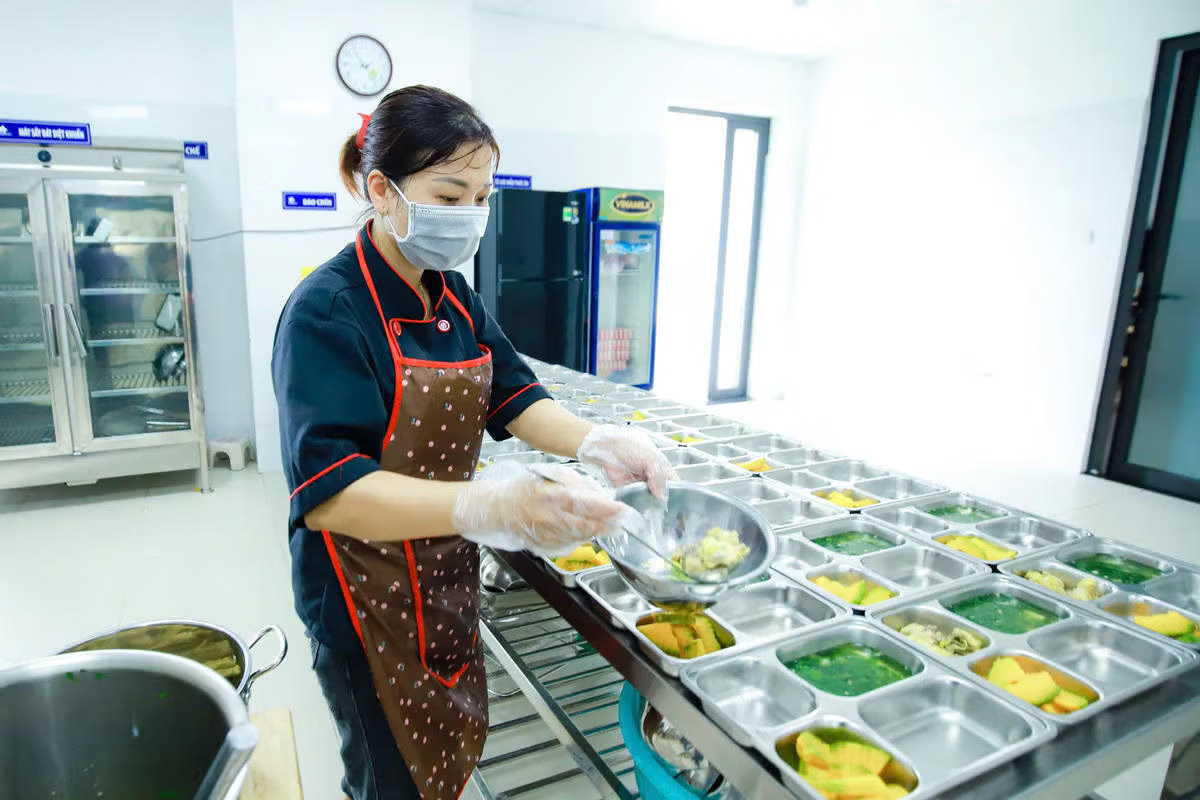 Chuẩn bị bữa ăn bán trú cho các em học sinh tại một trường học ở Hà Nội.