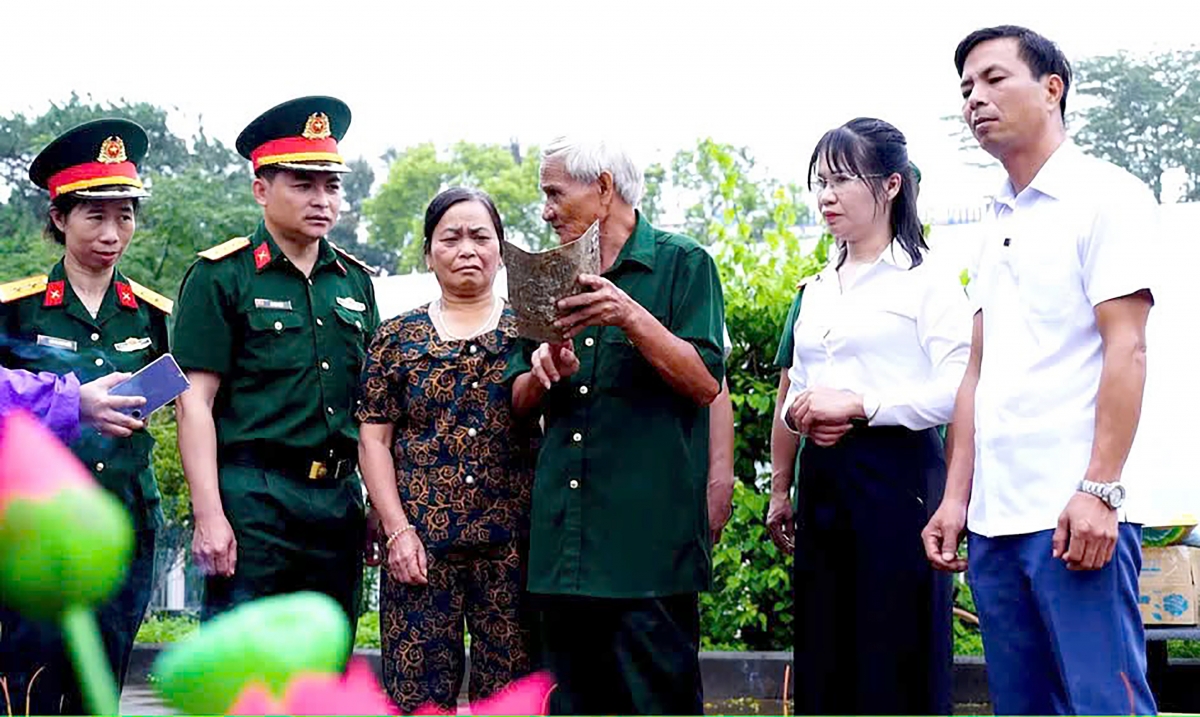Gia đình liệt sĩ Dương Văn Hải (quê ở xã La Hiên, tỉnh Thái Nguyên) tại Gia Lai đối chiếu di vật được phát hiện trong quá trình khai quật mộ liệt sĩ. Ảnh: Huy Bắc