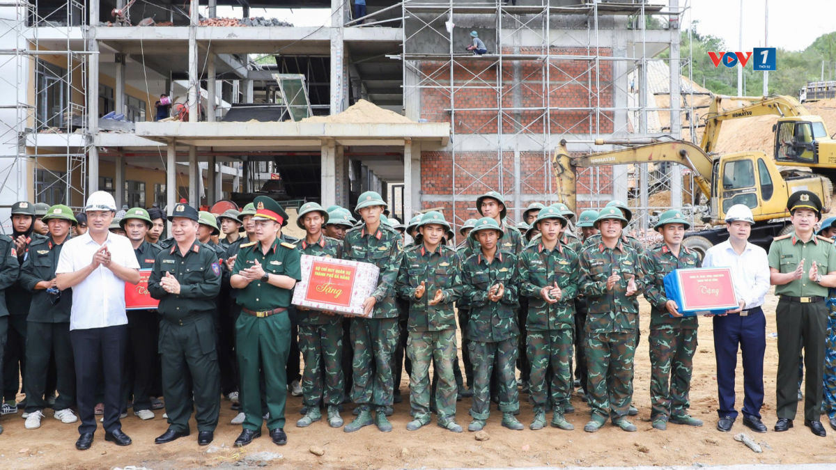 Ông Lê Ngọc Quang, Bí thư Thành ủy Đà Nẵng (áo trắng, bên trái) và ông Nguyễn Mạnh Hùng, Chủ tịch UBND thành phố Đà Nẵng (áo trắng, bên phải) tặng quà động viên lực lượng tham gia thi công trường học