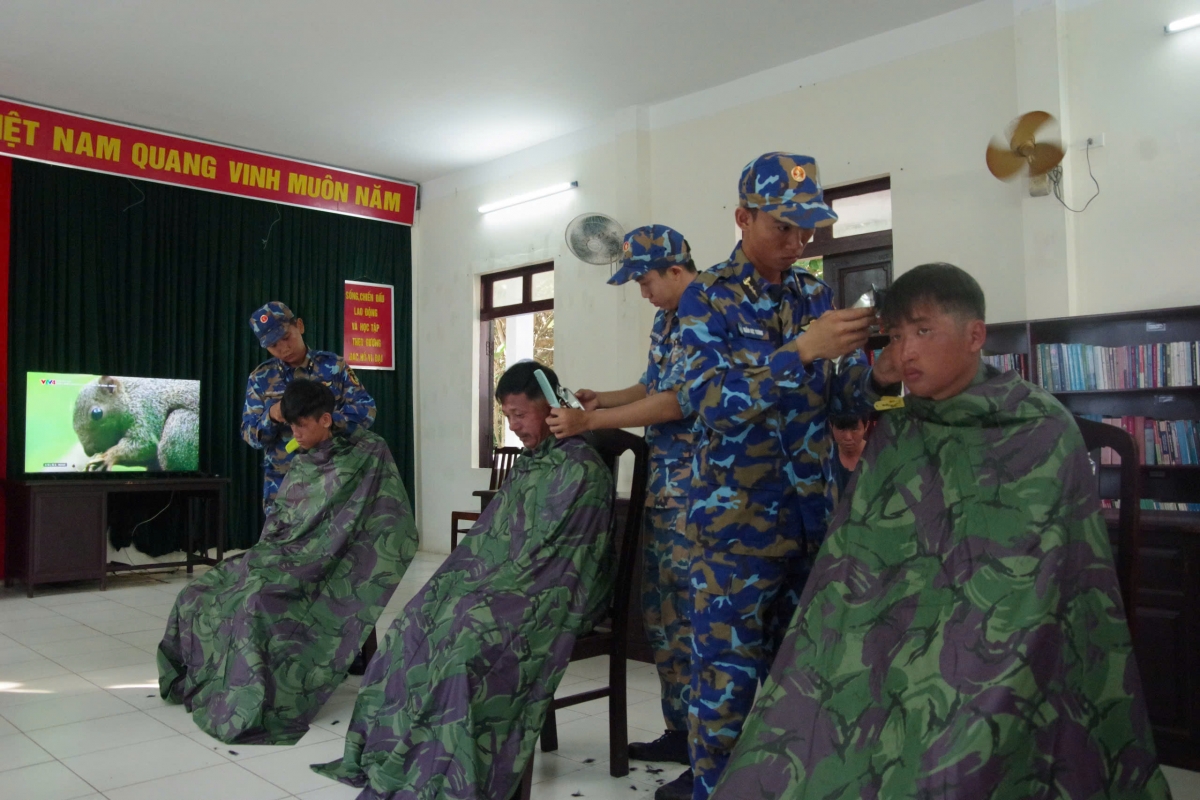 Cán bộ, chiến sĩ đang cẩn thận trong từng đường kéo cắt tóc cho ngư dân