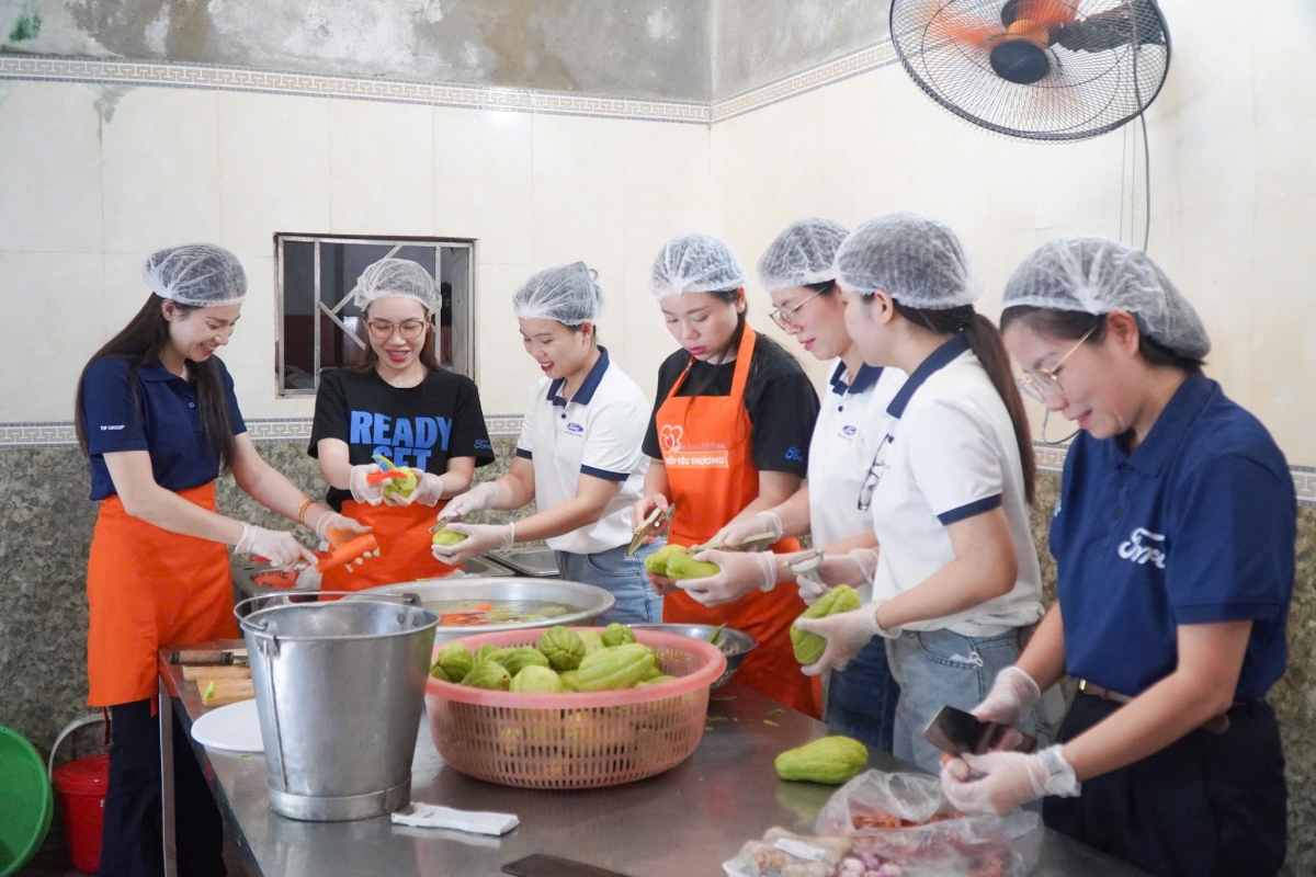 Các thành viên trong đoàn nấu ăn cho các em nhỏ. Ảnh Food Bank