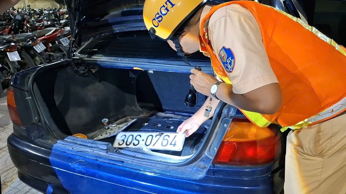 Bên trong cốp xe xanh lại có nhiều biển số trắng.