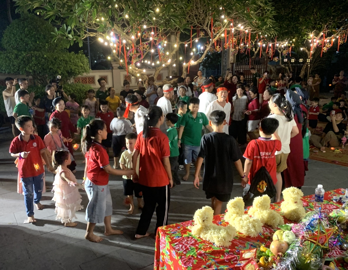 Các em học sinh nắm tay nhau vui Trung thu trong sân đình Hùng Lô.